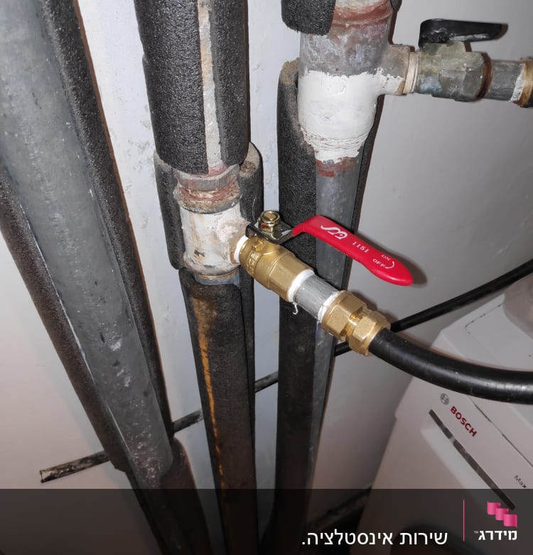 צינורות מבודדים עם ברז אדום ומחבר פליז